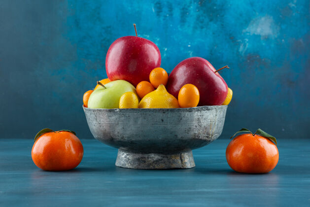 新鲜一碗各种新鲜水果放在蓝色的表面上沙拉整个生的