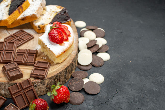 饼干前视图蛋糕片与饼干和巧克力条在黑暗的背景前面美味巧克力