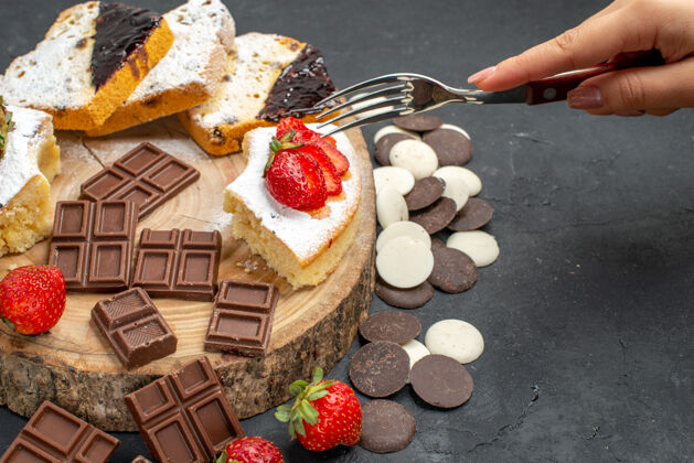 巧克力前视图蛋糕片与巧克力和饼干在黑暗的背景新鲜奶油草莓
