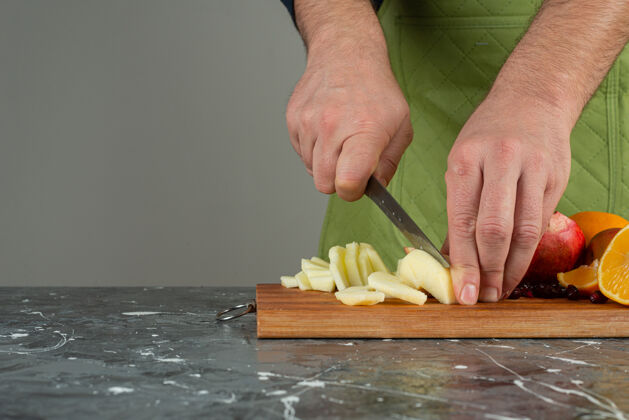 男男手切新鲜苹果放在桌上的木板上苹果切片水果