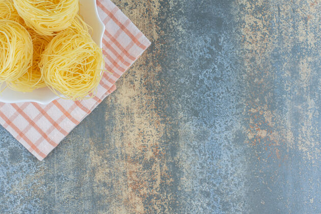 意大利面薄薄的意大利面条放在碗里的毛巾上 放在大理石背景上美味茶毛巾有味道