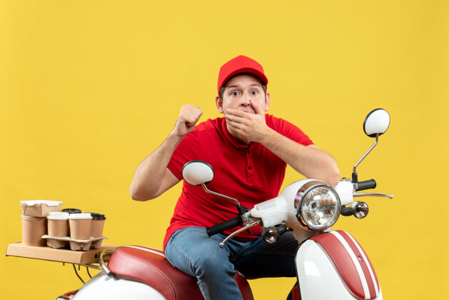 运动顶视图好奇的年轻人穿着红色上衣和帽子传递命令指向黄色背景的背面背景指点红色