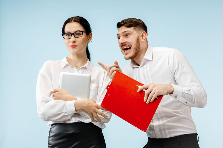工作商业伙伴关系的概念年轻快乐微笑的男女站在工作室蓝色背景下女孩自信个人