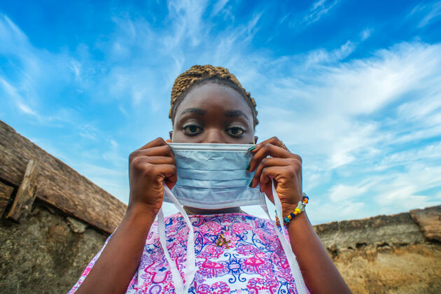 疾病一个年轻的非洲妇女戴上防护面罩的低角度镜头防护医疗保健安全