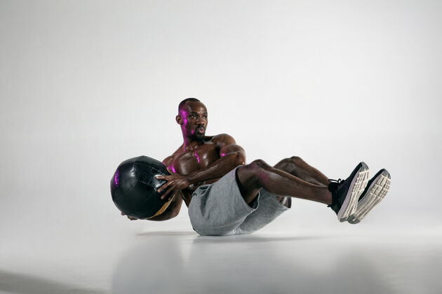 人准备最好的年轻的非洲裔美国人在灰色背景下的健美训练肌肉发达的单一男模在运动服与球概念的运动 健美 健康的生活方式健美运动举重
