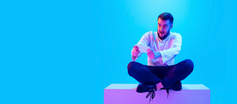 情绪白种人的肖像在霓虹灯下的蓝色工作室背景上孤立美丽的男模人类情感的概念 面部表情 销售 广告广告的复制空间明亮胡须企业