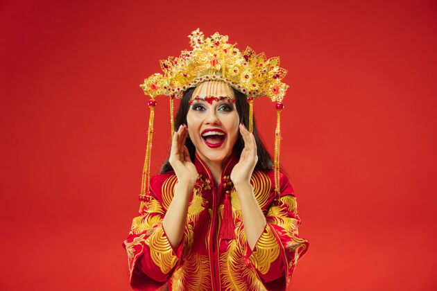 女演员中国传统的优雅女子在摄影棚的红色背景美丽的女孩穿着民族服装中国新年 优雅 优雅 表演者 表演 舞蹈 女演员 情感概念情感喊叫肖像