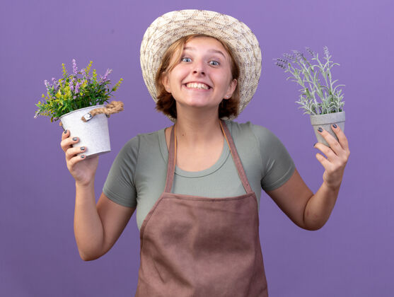 斯拉夫快乐的年轻斯拉夫女园丁戴着园艺帽 手里拿着紫色花盆里的花花园帽子女性