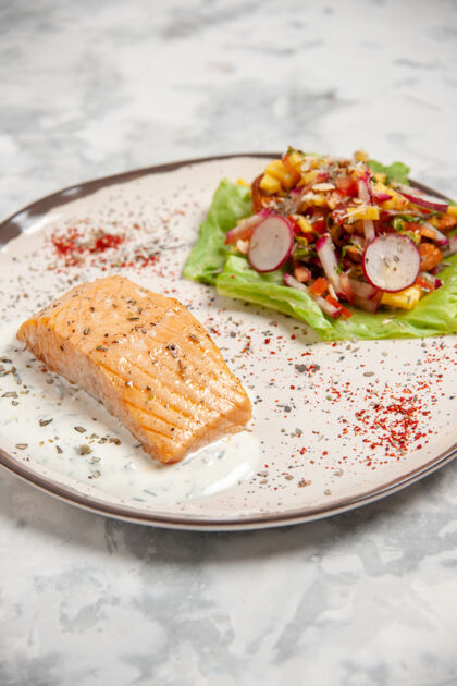 美味鱼粉和美味沙拉的侧视图 放在一个盘子上 白色的污渍表面晚餐食物午餐