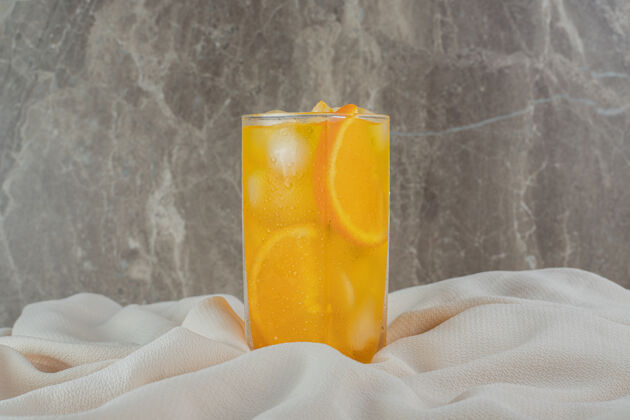 营养一杯橙汁加冰块放在棉布上柑橘衣服立方体