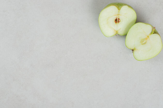 可口在灰色的表面上切半个新鲜苹果生的有机苹果