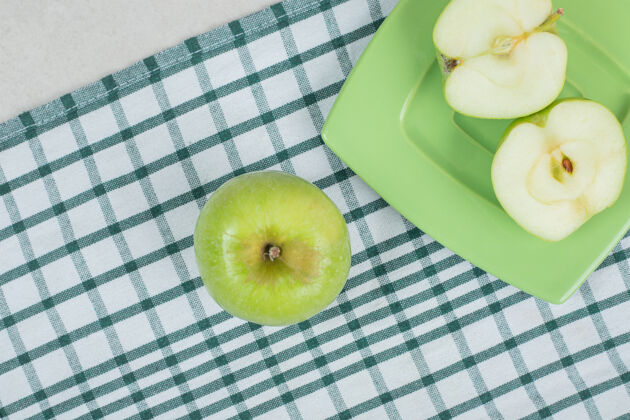 苹果在绿盘子上切半个青苹果切成两半水果可口