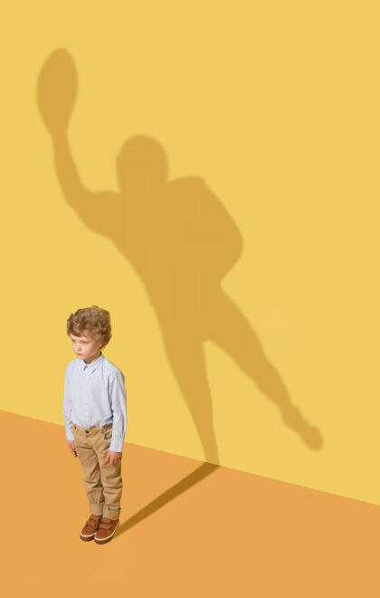团队最好的队员童年和梦想的概念概念形象与儿童和阴影在黄色的工作室墙上小男孩想成为美式足球运动员 建立一个体育事业表现著名创意