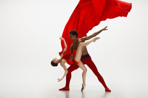 衣服优雅的经典芭蕾舞者在白色的工作室背景上独立地跳舞一对穿着鲜红衣服的舞者就像是酒和牛奶的结合优雅 艺术家 动作 动作的概念姿势现代灵活