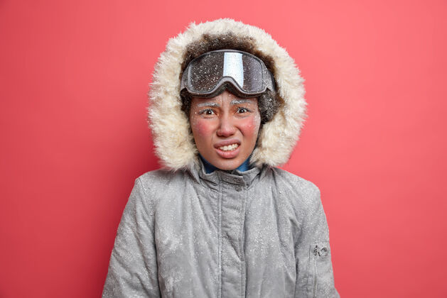 爱好喜欢冒险的不满意的女人冻得发抖在暴风雪中花了很多时间去滑雪穿冬天的夹克水晶美国美丽