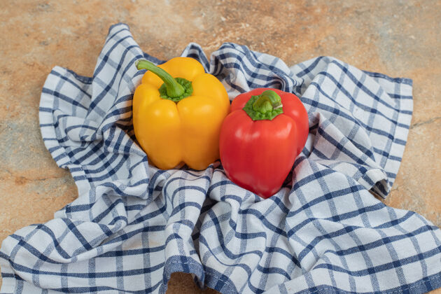 美味两个五颜六色的辣椒躺在桌布上新鲜饮食营养