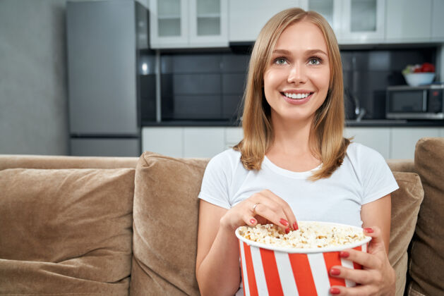 女人年轻女人在家看电影吃爆米花房间独自享受