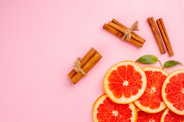 可食用水果美味的葡萄柚和肉桂的粉红色表面多汁水果片俯视图水果肉桂切片