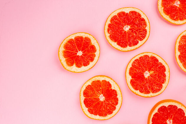 水果顶视图美味的葡萄柚切片多汁水果衬在粉红色的表面饮食新鲜果汁