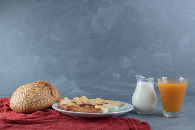薄煎饼早餐摆在大理石桌上的红桌布上美味果汁香肠