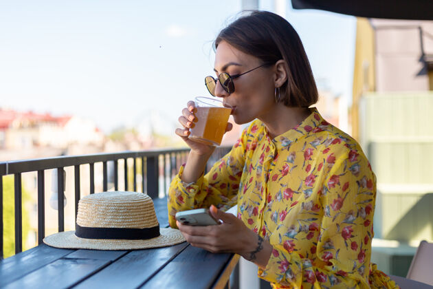 发酵穿着盛装的女人在夏日咖啡馆享受清凉的康普茶啤酒康普茶休息细菌