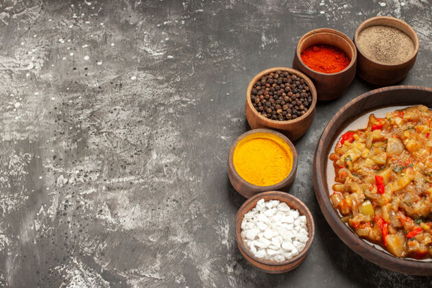 茄子沙拉顶视图烤茄子沙拉在碗和不同的香料在小碗在黑暗的表面食物橄榄烹饪