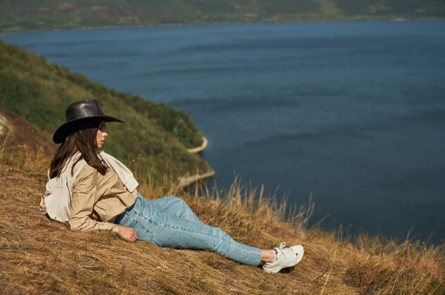 度假躺在高山上欣赏风景的女人自然河流徒步旅行