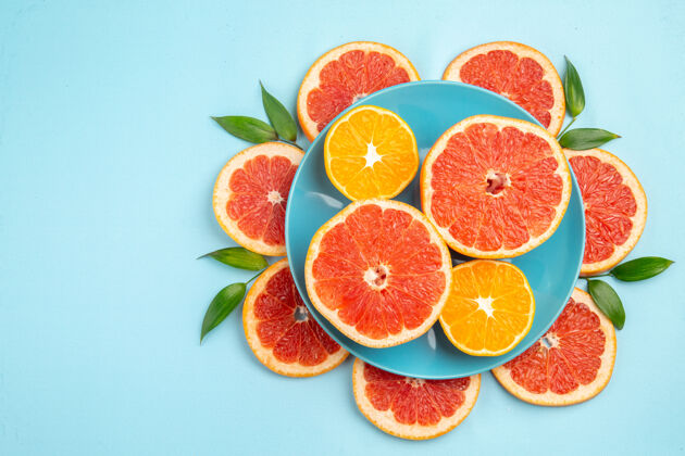 切片蓝色表面上美味的葡萄柚水果片俯视图柑橘食品农产品