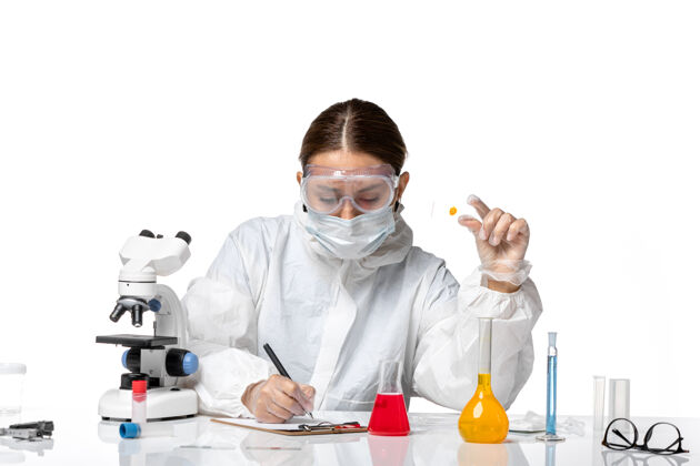 正面前视图：穿着防护服 戴着口罩的女医生在白色背景上写下医学病毒——健康大流行病毒专业医生防护