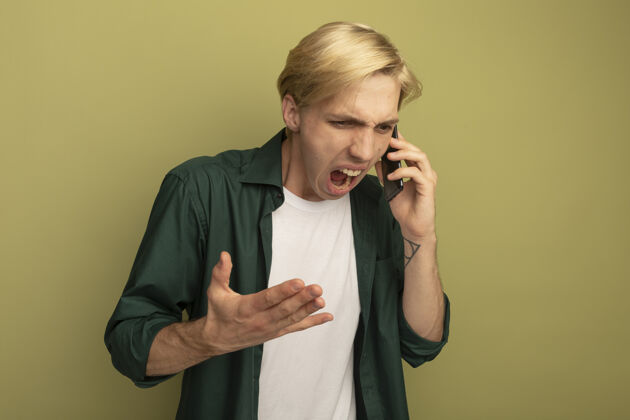 低落愤怒地低头看着穿着绿色t恤的金发小伙子在电话里讲话说话男人穿