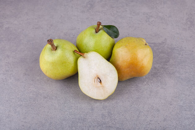 食物成熟的绿梨 叶子放在石头表面上有机营养多汁的