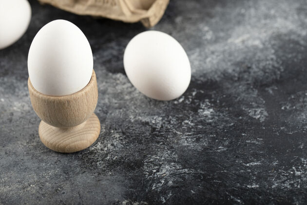 新鲜一个木制的鸡蛋杯 里面有煮熟的鸡蛋母鸡饮食木材