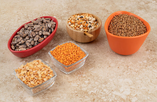 生的美味的扁豆和豆子放在大理石表面的盘子里美味豆类食物