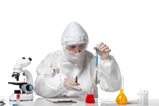 男医生正面图：男医生穿着防护服 戴着面罩 因为在空白处有蓝色溶液的瓶子实验室外套溶液专业