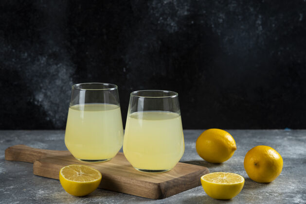 马克杯在木板上放两杯柠檬汁柠檬自制的水