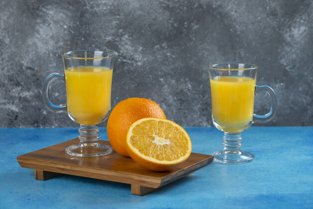 美味在木板上放两杯橙汁爽口杯子橙子