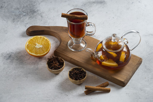 木头一个茶壶 上面放着茶和一片橘子在木板上黄色棕色新鲜