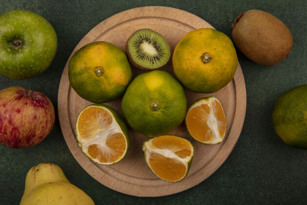 柑橘在苹果和梨架上俯瞰橘子片和猕猴桃片观点绿色切片