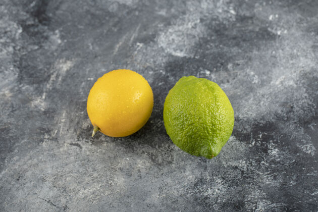 明亮黄色和绿色的柠檬在大理石表面柠檬农业组