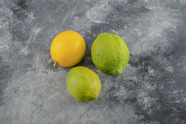 农业黄色和绿色的柠檬在大理石表面组成熟素食
