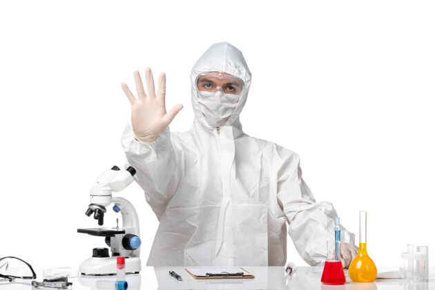 健康正面图：男医生穿着防护服 戴着口罩 因为科维德把手放在白色空间上病毒显示保护