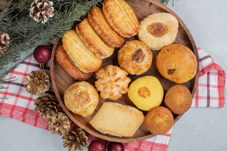 木头一个木制盘子里装满了甜糕点 还有圣诞球和松果松果糖圣诞节