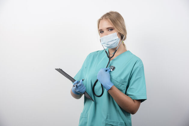 护士女医生拿着剪贴板 戴着医用口罩高质量的照片人女士制服