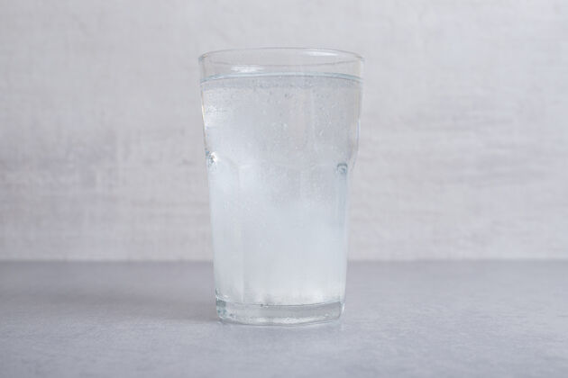 玻璃一杯纯正的冷水 背景是灰色的冷液体滴