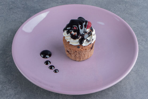面包房紫色盘子上的甜奶油蛋糕食品浆果甜点