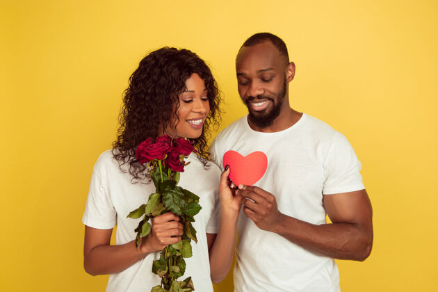 团结花与心情人节庆典 黄色工作室背景上的快乐非洲裔美国夫妇人类情感的概念 面部表情 爱情 关系 浪漫的节日心情人庆祝