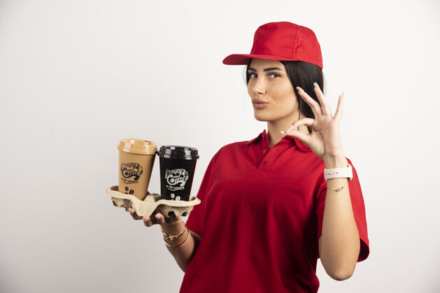 制服女信使与咖啡显示ok标志高品质的照片咖啡快递肖像