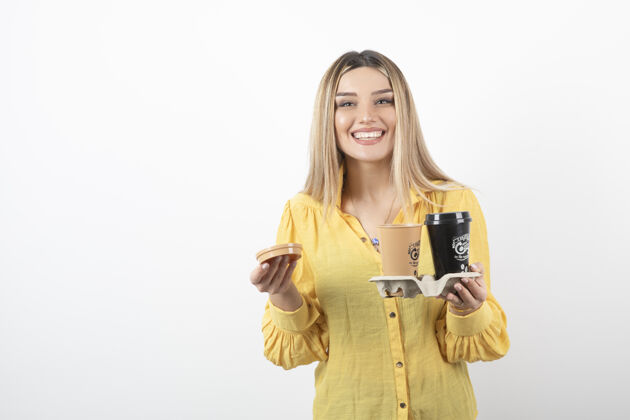 盖子年轻女子微笑着端着咖啡的画面年轻站着杯子