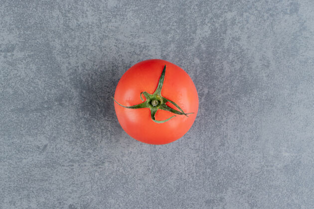 食物一个新鲜的红色番茄放在大理石表面好吃的西红柿蔬菜