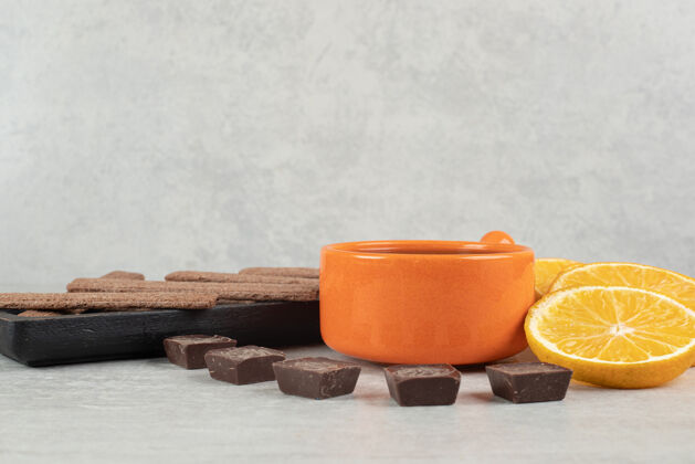 美味咖啡 橘子片 巧克力和饼干放在大理石表面水果杯子饼干